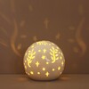 Ceramic LED Celestial Ball Light lit up in dark space with cutout reflections on wall