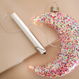 Hanging Pink Glitter LED Moon Light with Battery Pack on Beige Background