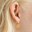 Close Up of Celestial Charm Huggie Hoop Earrings in Gold on Model