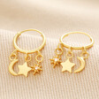 Celestial Charm Huggie Hoop Earrings in Gold on Beige Fabric