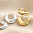 Sterling Silver Faceted Dome Huggie Hoop Earrings with gold version on beige material
