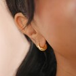 Close up of Gold Sterling Silver Faceted Dome Huggie Hoop Earrings on model