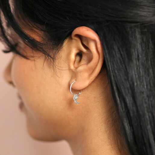 Sterling Silver Moon and Star Charm Hoops on model in front of neutral backdrop
