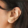 Close up of Mother of Pearl Star Stud Earrings in Gold on model