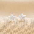 Sterling Silver Glitter Enamel Star Stud Earrings on top of beige surface