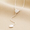 Sterling Silver Crystal Heart Lariat Necklace close up on beige fabric