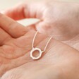 Model holding Sterling Silver Crystal Hoop Pendant Necklace in palm of hand