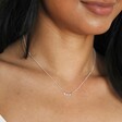 Close up of Sterling Silver Tiny Triplet Heart Bar Necklace on model