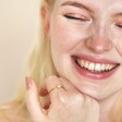 Model smiling wearing Gold Sterling Silver Crystal and Opal Cluster Ring against beige backdrop