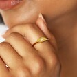 Close up of Gold Sterling Silver Crystal Star Signet Ring on model with hand on chin