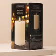 Cream Ribbed Wax LED Pillar Candle in packaging box against neutral coloured backdrop