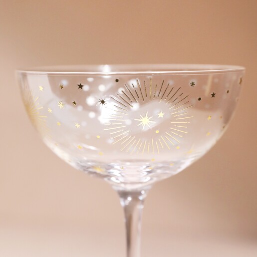 Close up of Gold Star Coupe Glass against beige backdrop