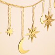 Close up of Gold Moon and Star Metal Garland in front of beige coloured backdrop