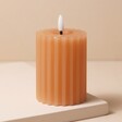 Pink Ribbed Wax LED Pillar Candle Unlit on Beige Background