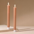 Set of Two Pink Ribbed Wax LED Dinner Candles on Beige Surface