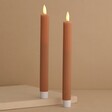 Set of Two Pink Ribbed Wax LED Dinner Candles on Plain Background