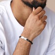Close up of Men's Double Braided Leather Bracelet in Black on model with hand on chin