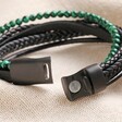 Clasp on Men's Malachite Bead and Leather Layered Bracelet in Black open on top of beige coloured fabric