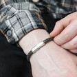 Model wearing Men's Navy Antiqued Woven Leather Bracelet holding band