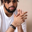 Men's Onyx Bead and Leather Triple Layered Bracelet on model with hands clasped together in front of neutral coloured backdrop