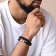 Close up of Men's Onyx Bead and Leather Triple Layered Bracelet on model with hand on chin