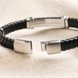 Close up of clasp on Men's Stainless Steel Feature Braided Leather Bracelet in Black undone on top of beige coloured material