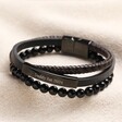 Personalised Men's Onyx Bead and Leather Triple Layered Bracelet on top of beige coloured fabric