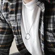 Close Up of Men's Stainless Steel Hoop Pendant Necklace on Model Sat Down