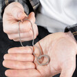 Model Holding Men's Stainless Steel Hoop Pendant Necklace in Hands