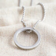 Close up of Pendant on Men's Stainless Steel Hoop Pendant Necklace on Neutral Fabric