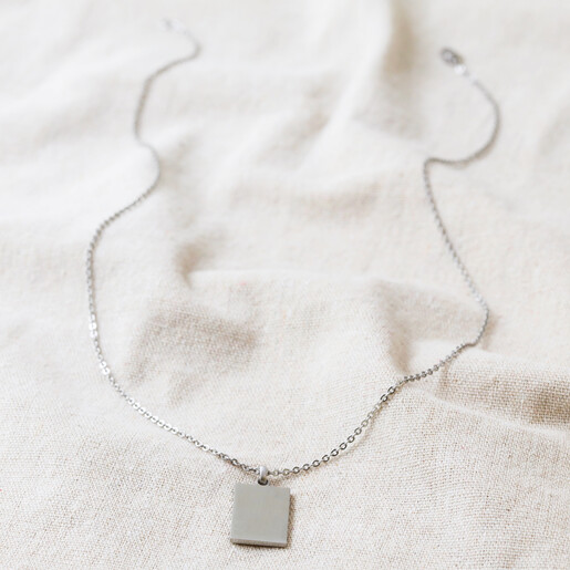 Full Chain of Men's Stainless Steel Tag Pendant Necklace on Beige Fabric