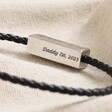 Close Up of Clasp on Personalised Men's Thin Woven Leather Bracelet in Black on Beige Fabric