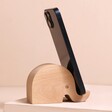 Wooden Elephant Phone Holder with phone on in front of neutral coloured backdrop