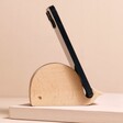 Wooden Whale Phone Holder with phone on top in front of neutral backdrop