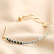 Navy Ombre Stone Beaded Bracelet in Gold laid out across beige coloured fabric