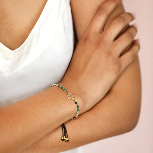 Model With Crossed Arms Wearing Heart Chakra Charm Bracelet in Gold