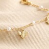 Close Up of Bee, Pearl, Butterfly and Heart Charm Bracelet in Gold