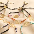 All Styles of Chakra Charm Bracelets in Gold on Beige Fabric