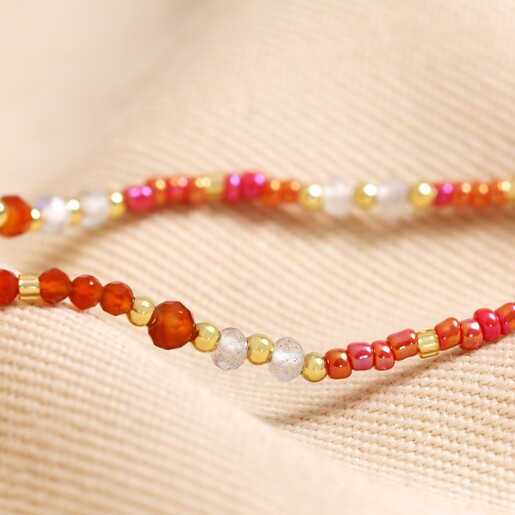 Close Up of Beads Close up of beads on Root Chakra Beaded Necklace in Gold on top of neutral coloured material