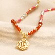 Root Chakra Beaded Necklace in Gold on top of beige coloured fabric