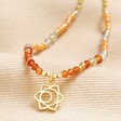 Sacral Chakra Beaded Necklace in Gold on top of beige coloured material