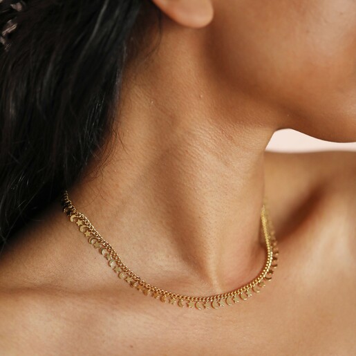 Close up of Tiny Moon and Star Charm Necklace in Gold on model