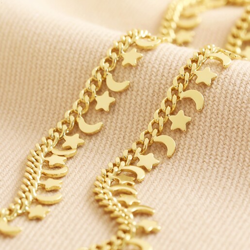 Tiny Moon and Star Charm Necklace in Gold on top of neutral coloured fabric