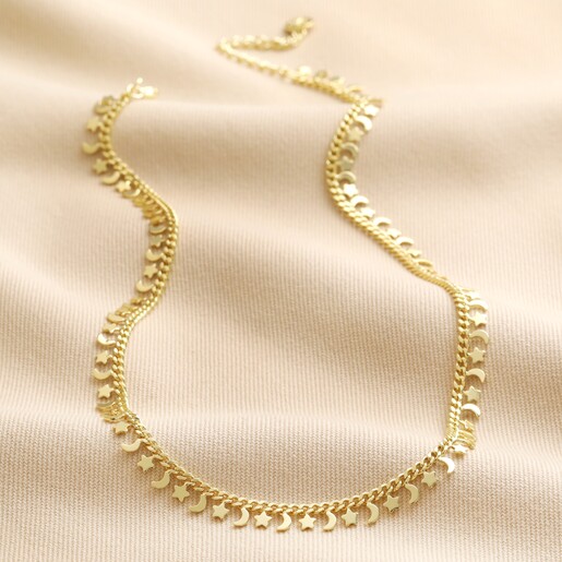 Tiny Moon and Star Charm Necklace in Gold full length on neutral coloured fabric