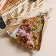 Posy in Happy Birthday Floral Wicker Gift Hamper on Plain Surface with Wicker Basket in Background 