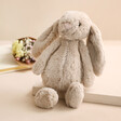 New Baby Gift Hamper Included Bunny with Posy in Background on Pink Surface