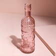 Pink Glass Bottle Vase against pink coloured backdrop