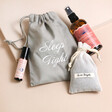 Sleep Tight Wellness Gift Set with roller ball, pillow spray and dried lavender laid out on plain pink surface