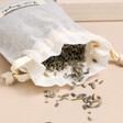 Dried lavender pouch from the Sleep Tight Wellness Gift Set with flowers spilling out onto pink surface 