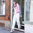 Model walking out of shop wearing Personalised Birth Flower Pink Winter Scarf